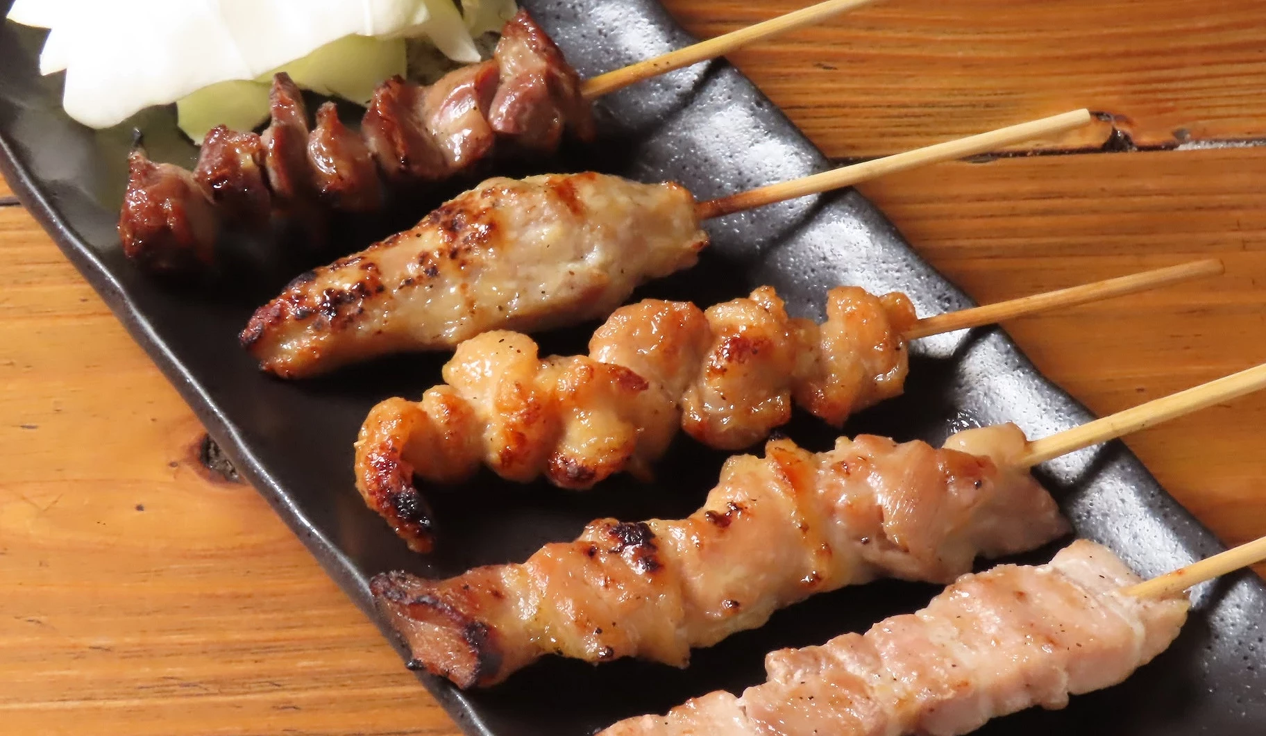 鐵盤上放了五種烤雞肉串