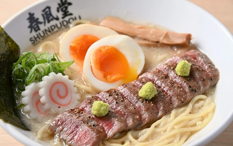 春風堂白碗盛豚骨拉麵,附牛肉片、溏心蛋與魚板