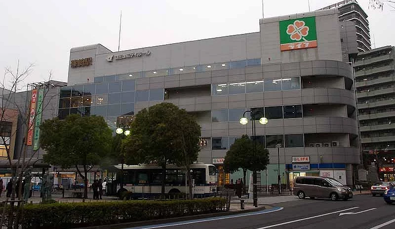 篠崎站外觀與周邊街道,站前可見建築物、路樹、公車與車