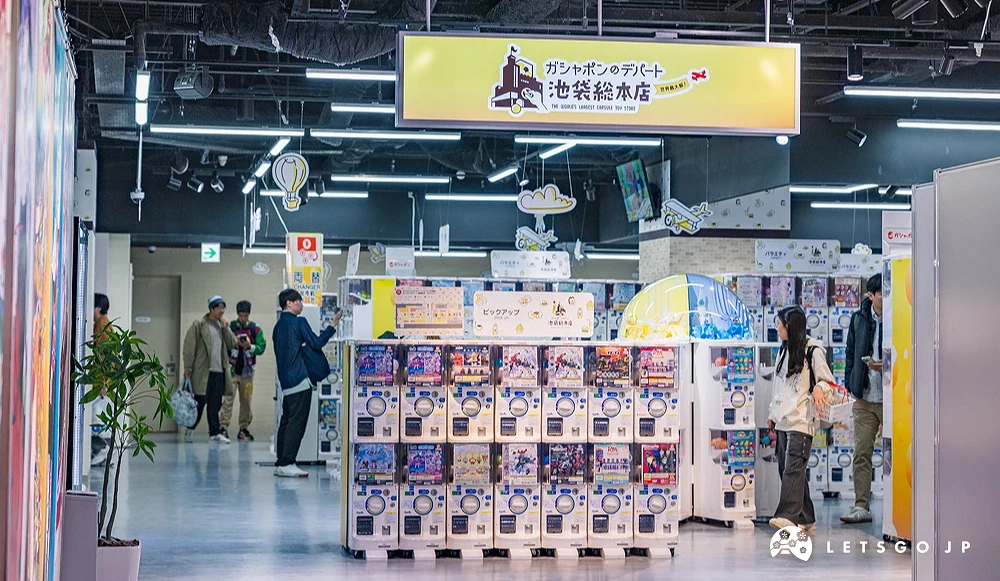 兩排的扭蛋機台上方有黃色的ガシャポンのデパート的招牌