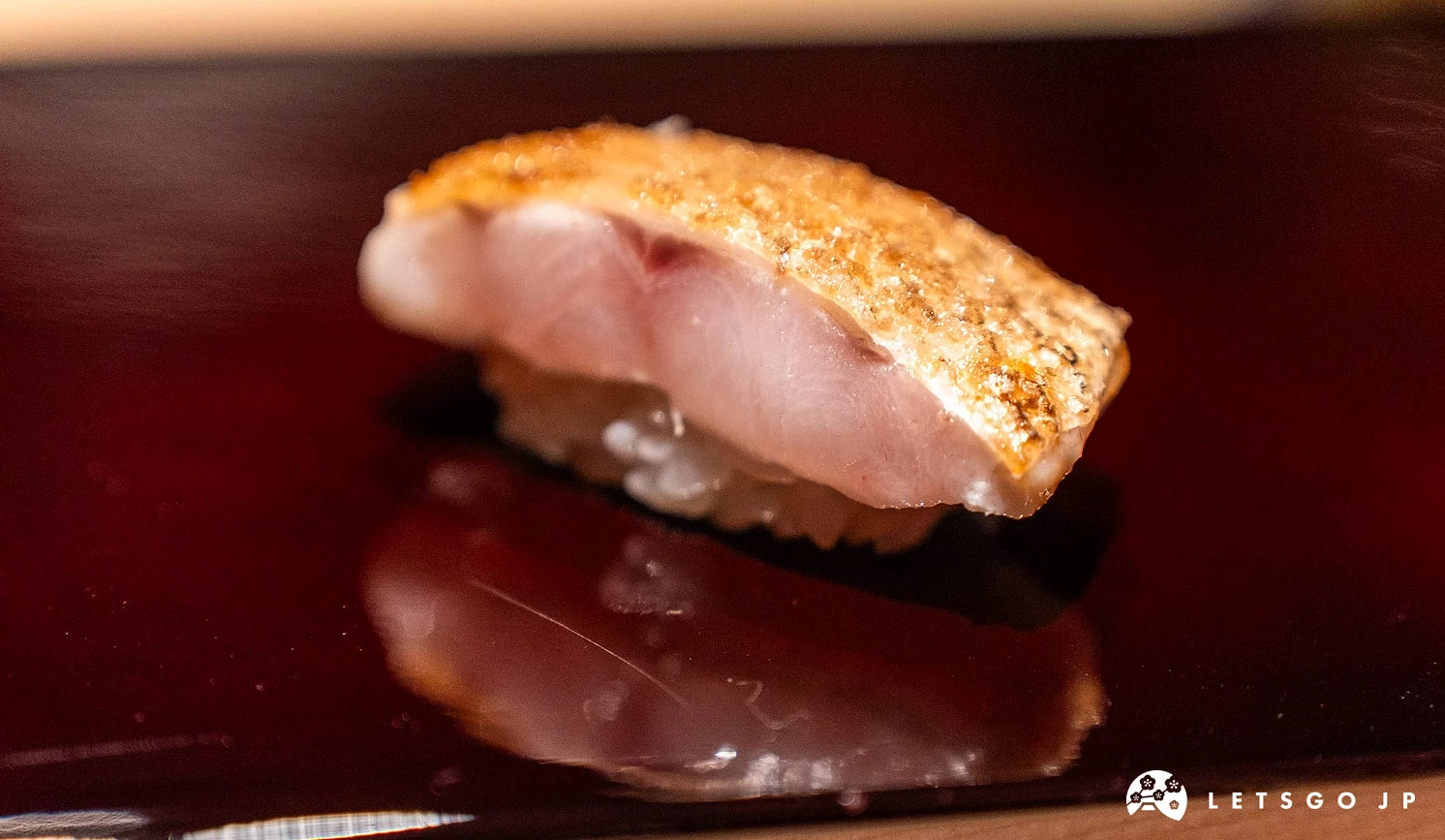 Sushi Kensuke 麻布十番的「喉黑魚昆布熟成炙燒壽司」外皮經過灸烤,香脆又帶焦香