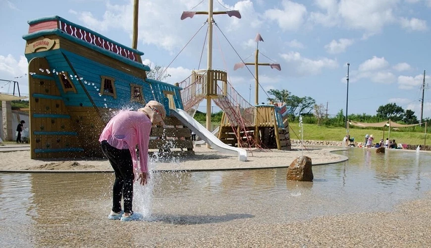 小孩子在海盜船造型的遊樂區旁邊玩水