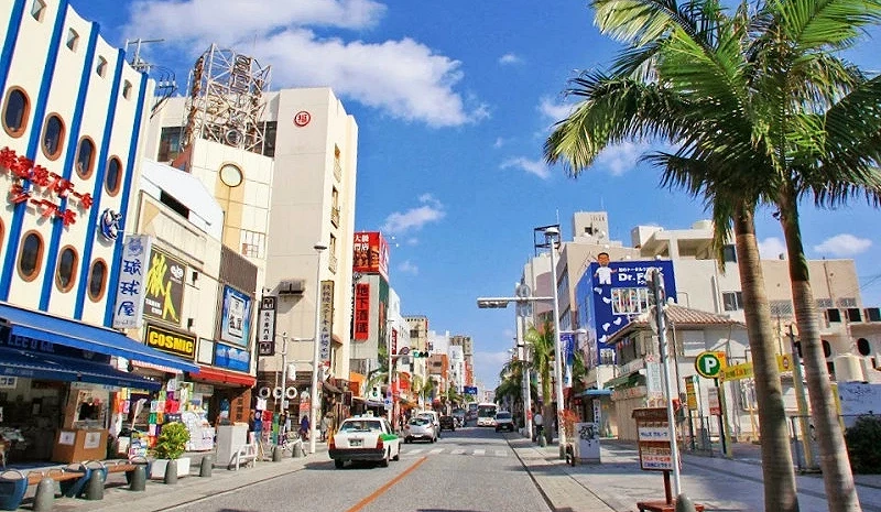 藍天白雲下面,兩邊有商店街,中間是大條馬路