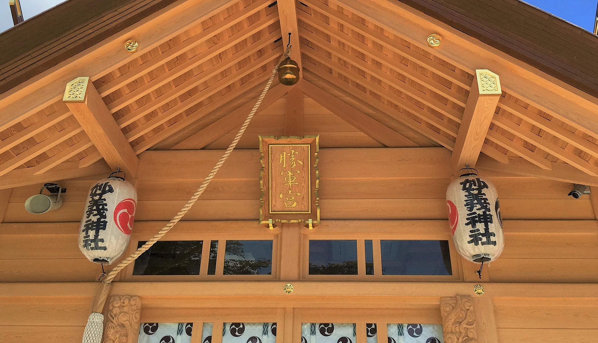 妙義神社拜殿屋頂細部,可見木造屋簷、注連繩與神社匾額。