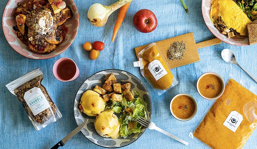 俯視早午餐食材與成品擺盤,含班尼迪克蛋、歐姆蛋、法式吐司、granola 及寫有日文標語的醬料包
