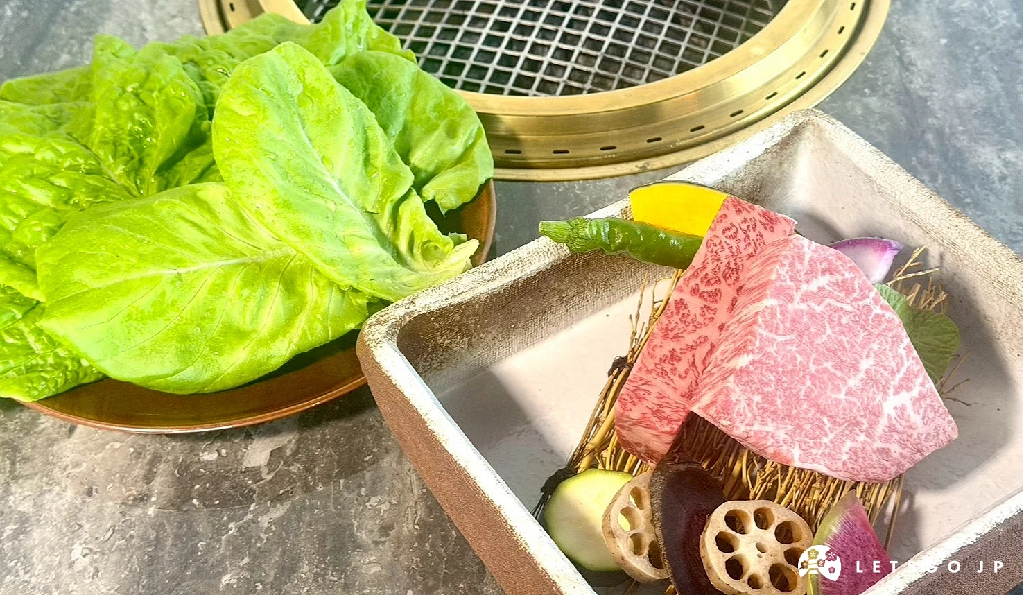 厚切米澤牛菲力與生菜、香菇、蓮藕等蔬菜一同擺放在燒肉桌上。