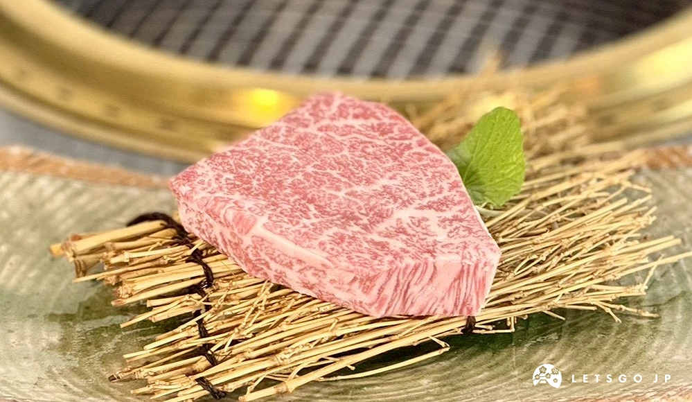 一塊厚切米澤牛菲力放在竹編葉片造型餐盤上,後方可見燒肉烤爐。