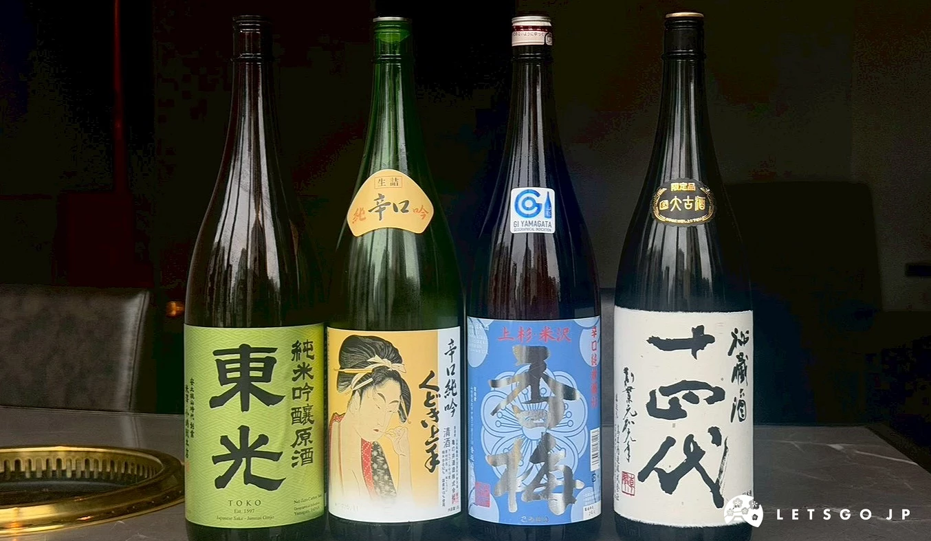 四瓶不同品牌的日本酒整齊擺放在桌面上。