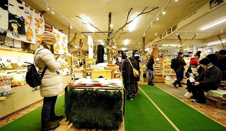 多名遊客在寫有日文標語的狐狸主題紀念品店內選購商品