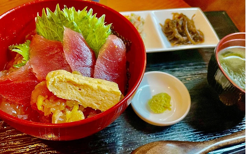 紅色大碗盛鮪魚生魚片蓋飯,附玉子燒、山葵與味噌湯