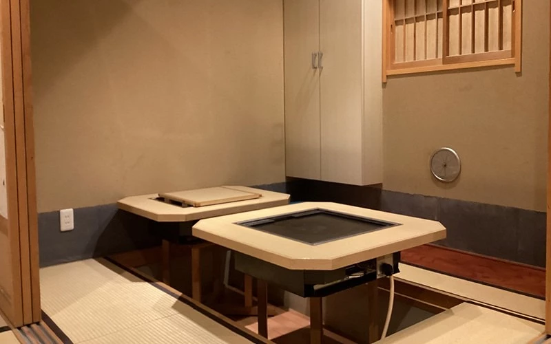 日式包廂內兩張八角形鐵板桌,榻榻米地板,木格子窗
