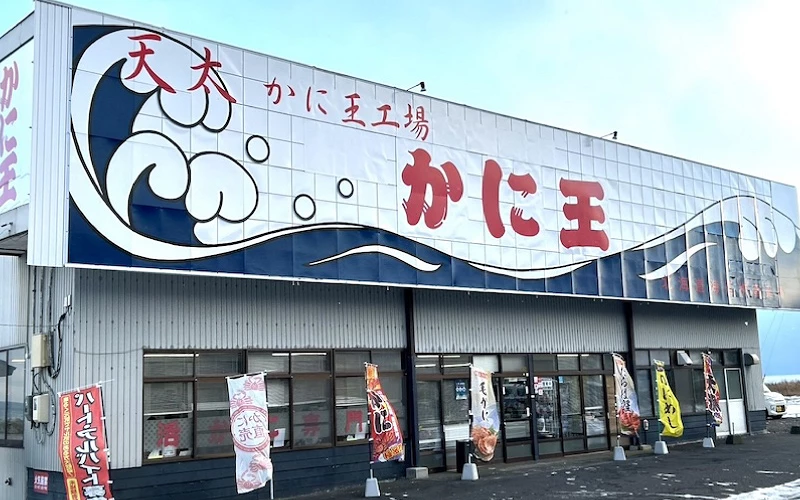 「かに王」蟹料理店外觀,門口立多面旗幟