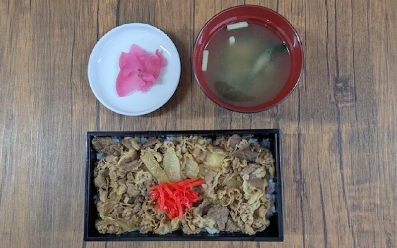 木桌上牛丼便當,附紅薑、味噌湯與醃薑