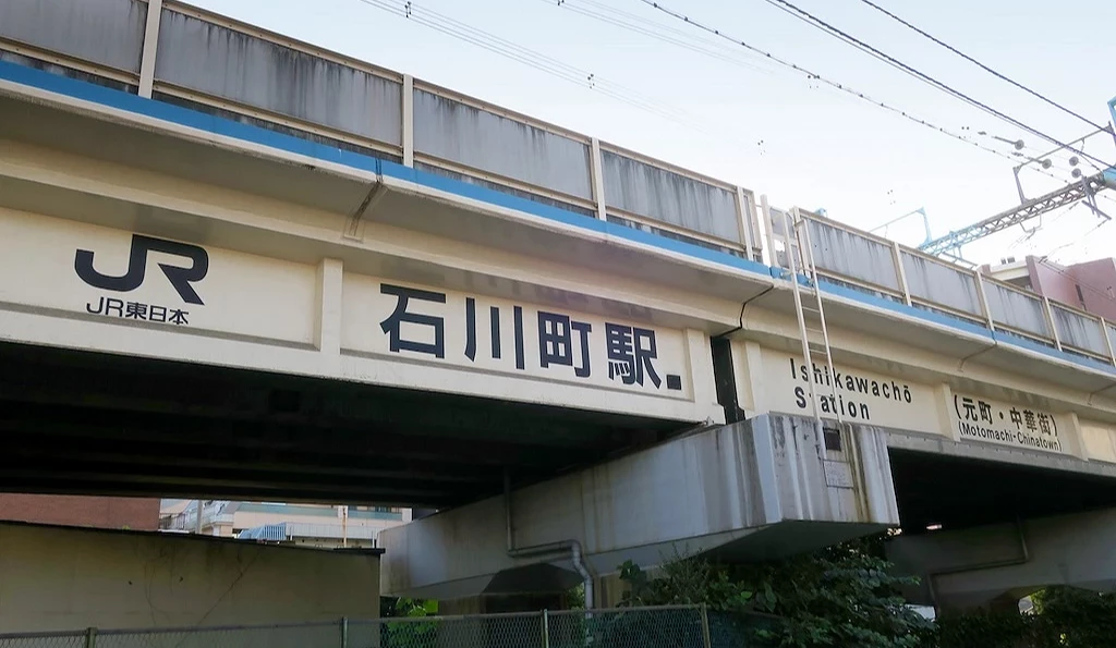 高架鐵軌上印著JR石川町站