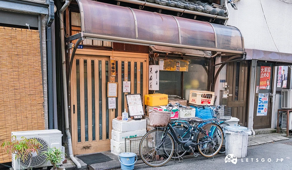 店外面很雜亂還有一輛腳踏車和垃圾桶