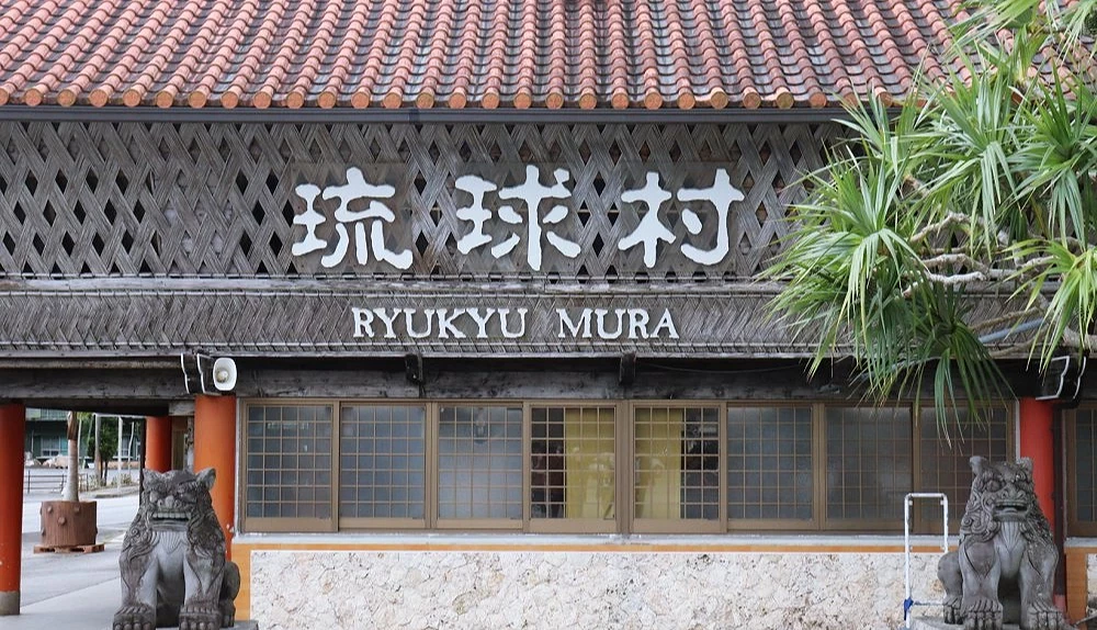 沖繩琉球村入口建築,有紅瓦屋頂與傳統木造外觀
