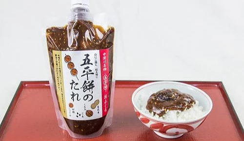 左邊是一袋塑膠袋裝的五平餅醬料,右邊有一碗飯,飯上面有一坨醬料。