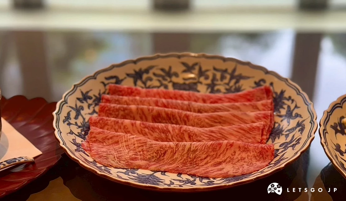 青花瓷圓盤整齊排列數片帶有細緻雪白大理石紋路的鮮紅米澤牛肉片。