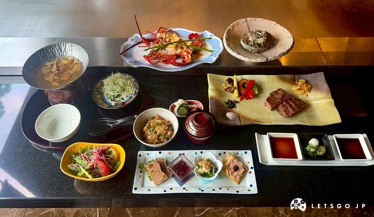 黑色桌面上擺滿豐富的日式鐵板燒套餐料理、沙拉、配菜與沾醬。