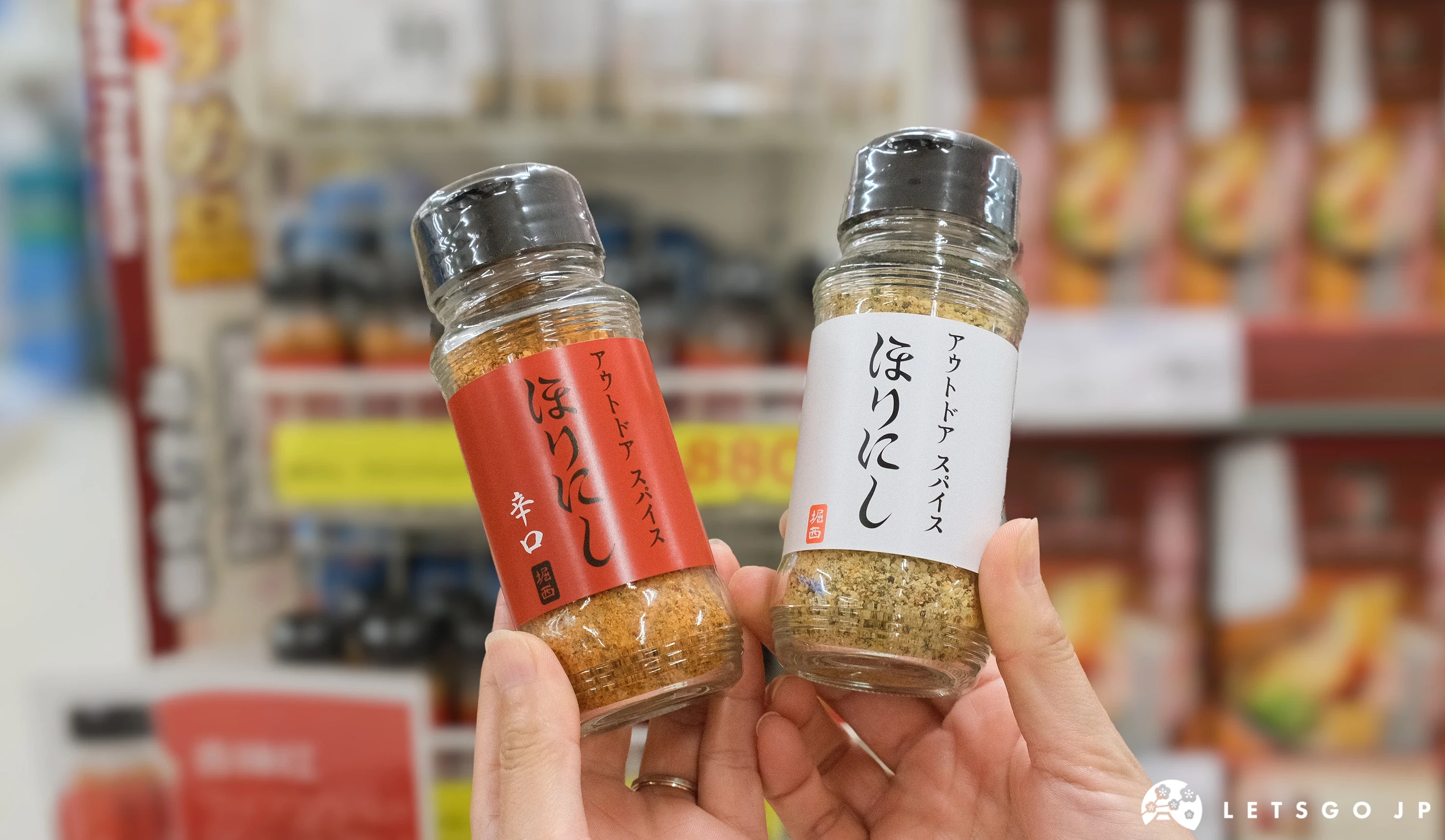 手拿「HORINISHI 萬用調味粉」原味與辣味
