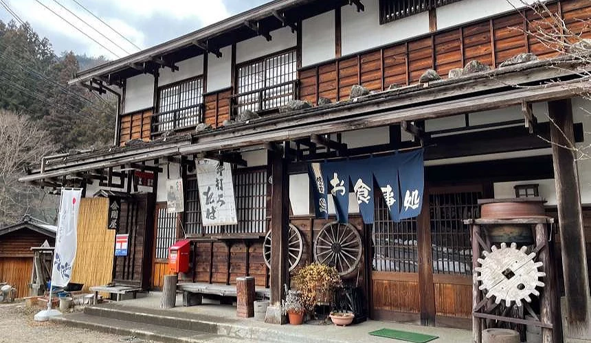 一棟兩層樓的日式建築,門口掛有「食事處」的門簾。