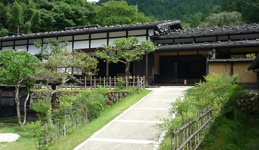 有一棟建築,前面有一條道路。道路左右兩邊是草地。
