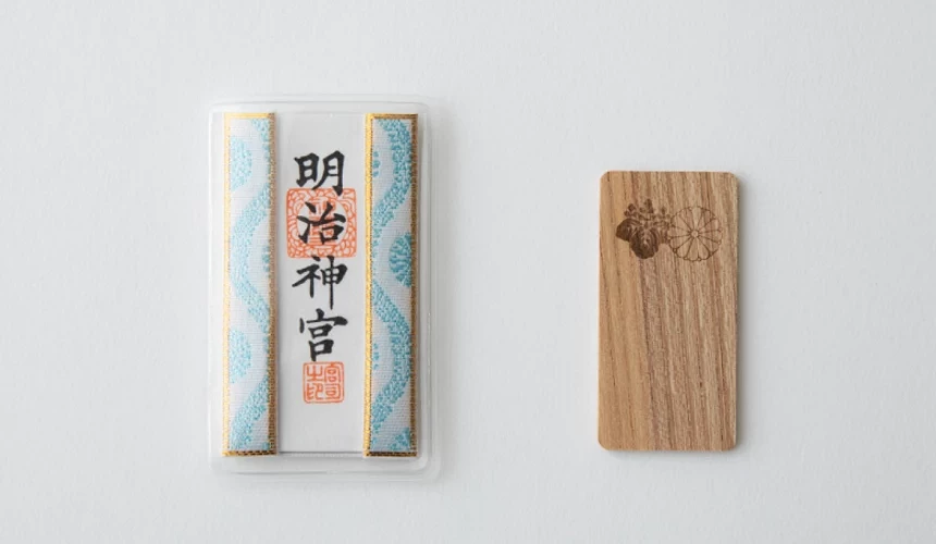右邊是一塊木板,左邊是寫著「明治神宮」字樣的御守。