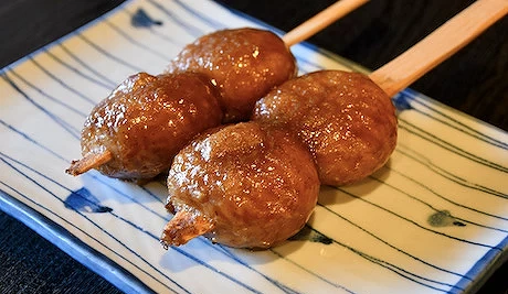有兩串咖啡色的烤餅,放在盤子上。