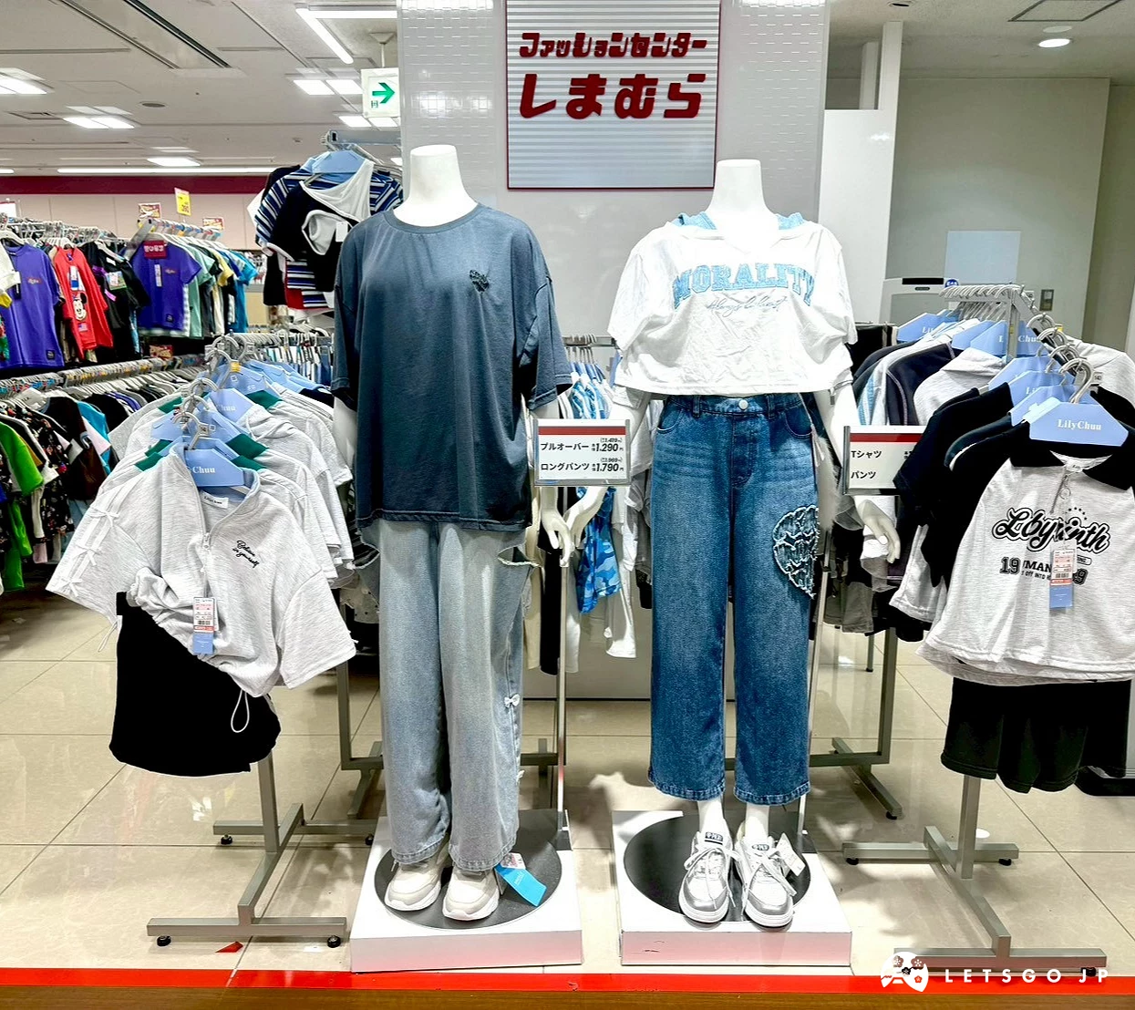 穿著寬鬆深灰色五分袖上衣與刷色牛仔寬褲的兒童/青少年尺寸人型模特兒,後方有紅色思夢樂招牌。