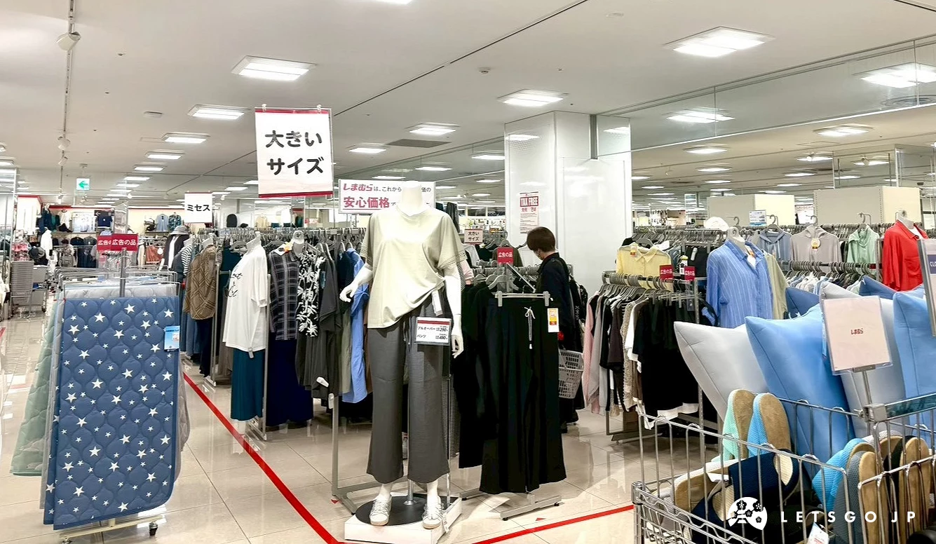 店內陳列的女性服飾區,前方立牌寫著日文「大尺寸」服飾區。