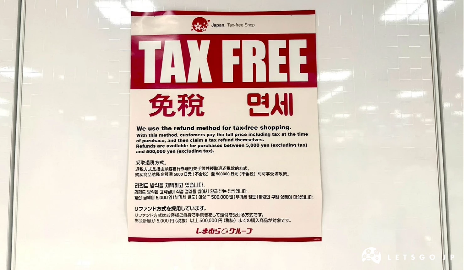 白色牆面上張貼著紅白配色的「TAX FREE 免稅 免세」中英韓日四國語言退稅告示牌。