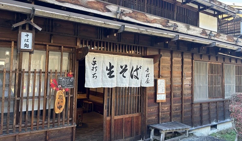 一棟日式建築,門口掛著「手打生蕎麥」的日文字樣。
