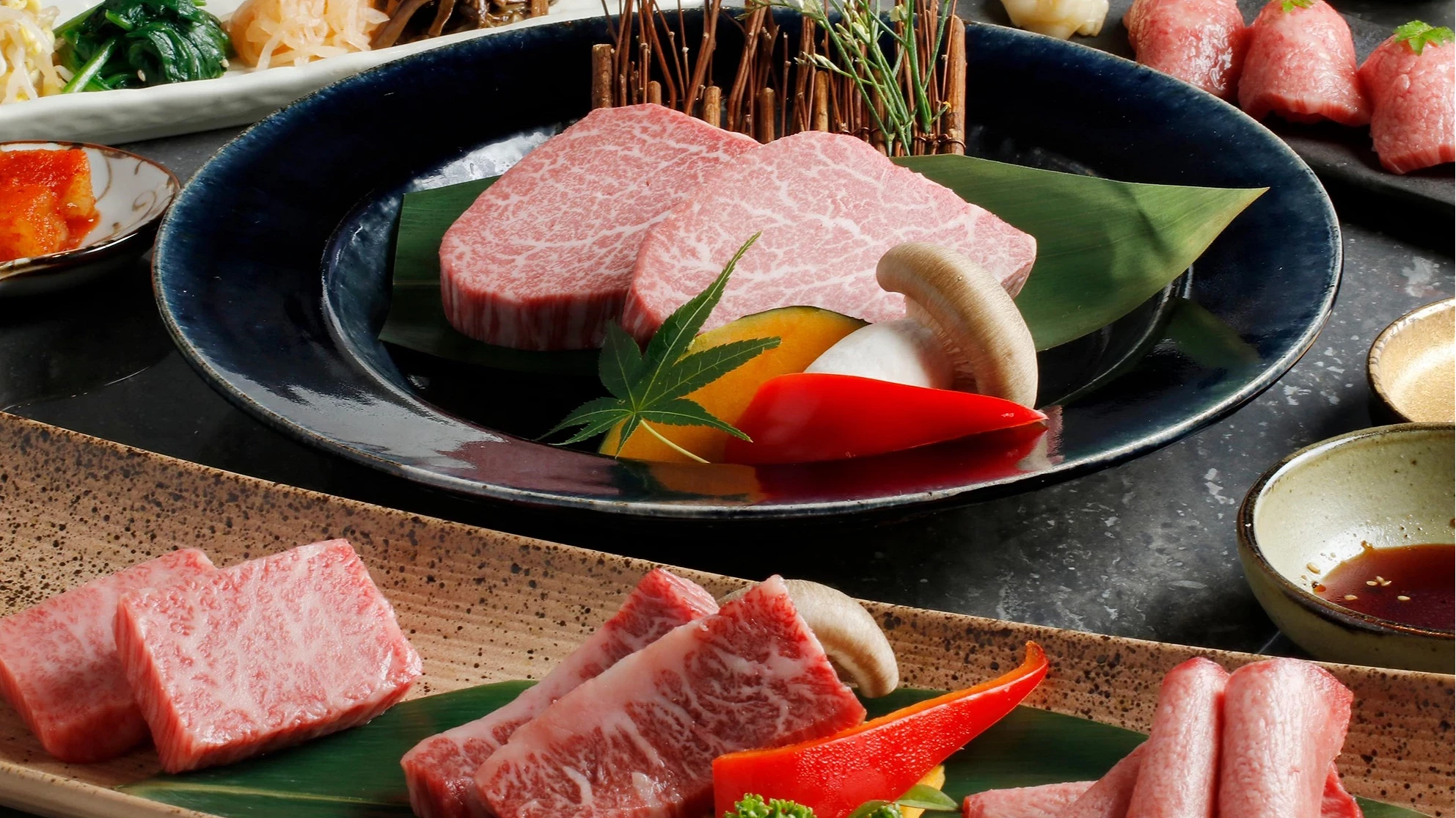米澤牛套餐包含多盤生牛肉、肉壽司、蔬菜與前菜,整齊擺放於餐桌上。