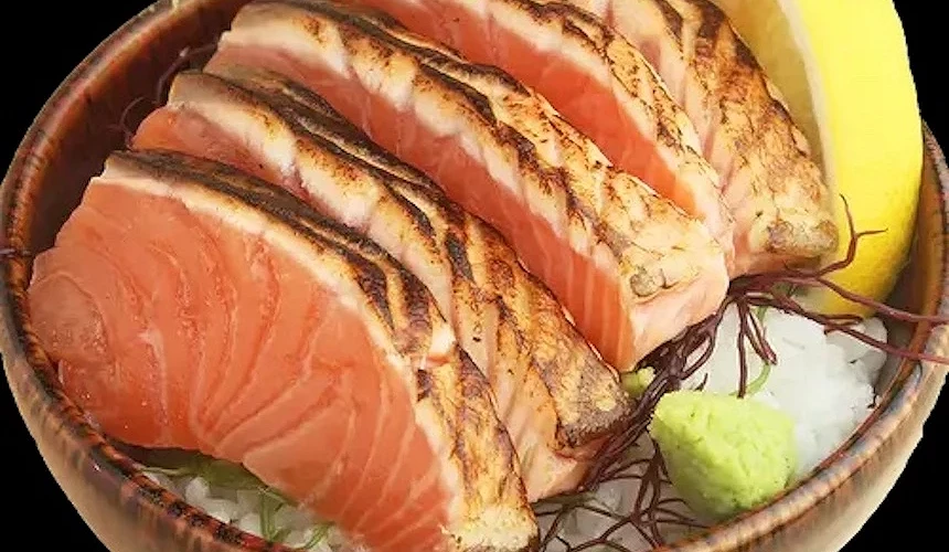 木製陶碗盛裝烤鮭魚與生鮭魚片,白飯與綠山葵點綴,日式海鮮丼飯精緻美味。