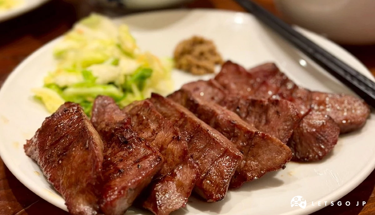 木質餐桌上擺放著盛裝在圓盤上的烤牛舌定食