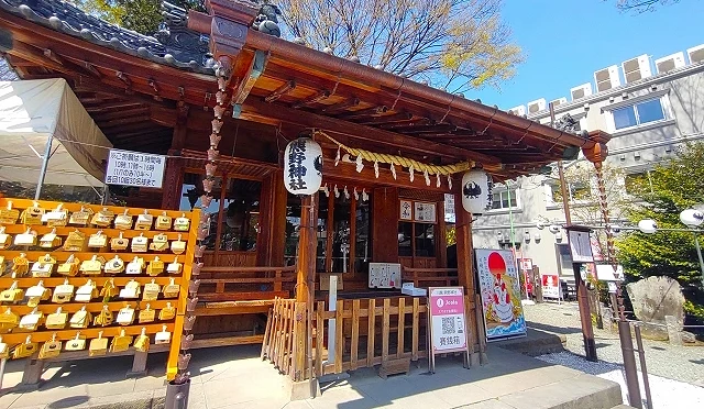 日本埼玉縣川越熊野神社社殿外觀,木造拜殿前懸掛著白燈籠與注連繩,左側立有掛滿繪馬的木架