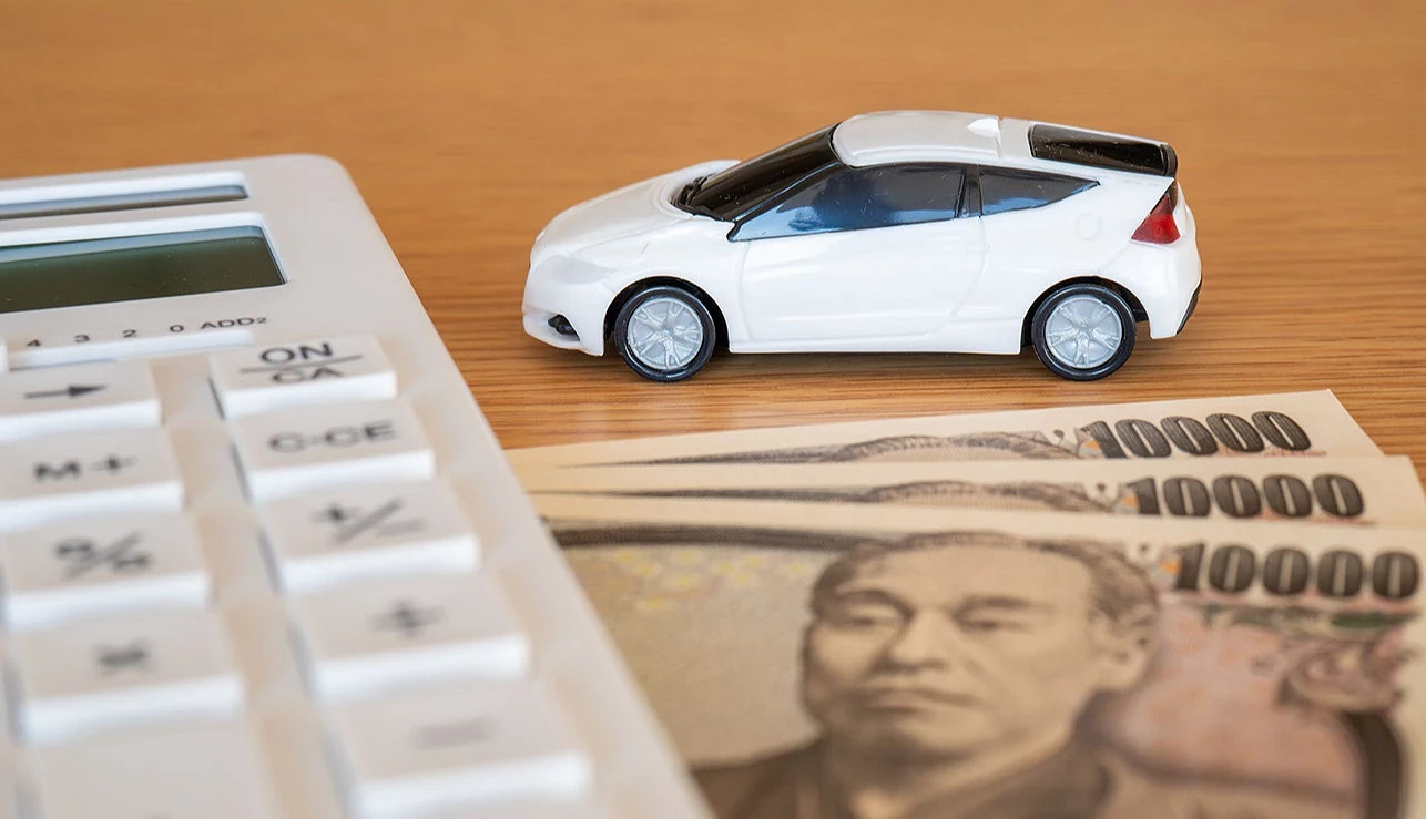 汽車模型與白色計算機和日幣鈔票