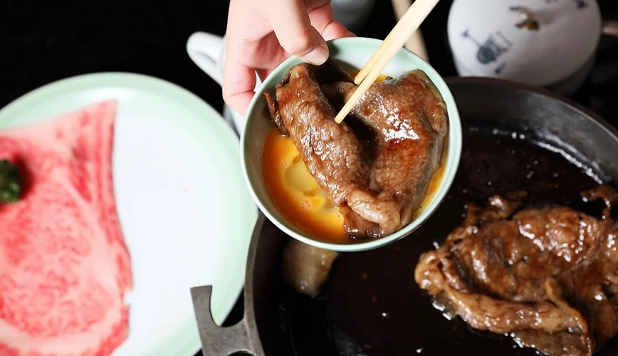 烤好的牛肉沾取蛋液