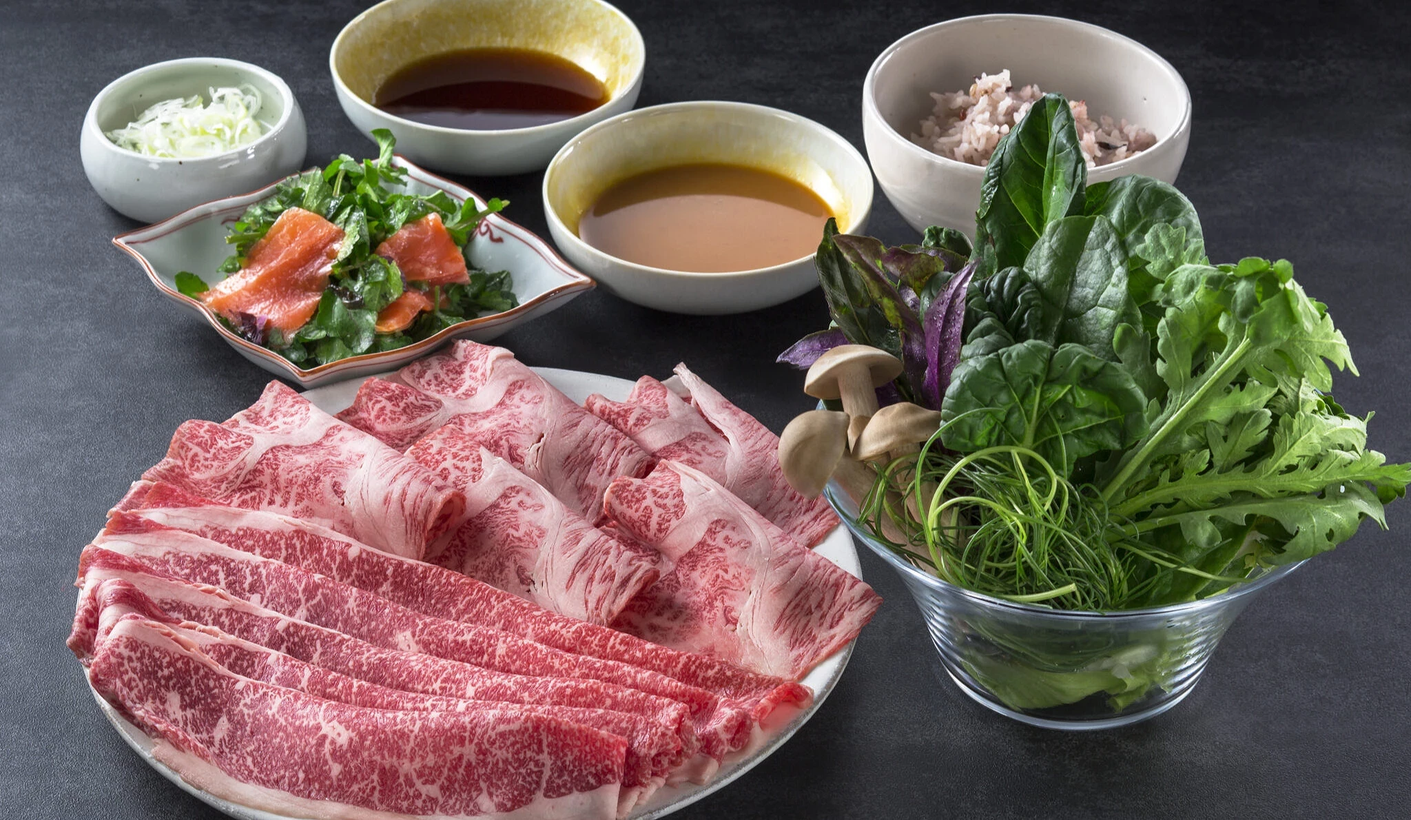涮涮鍋套餐。有一盤生牛肉片,一盤蔬菜盤,以及沙拉和沾醬。