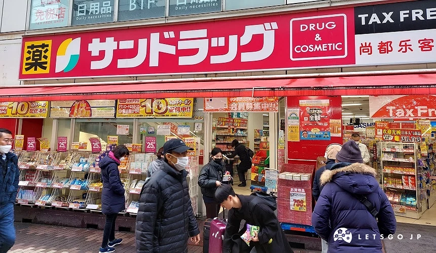 サンドラッグ藥妝店門口,多位顧客拖行李選購