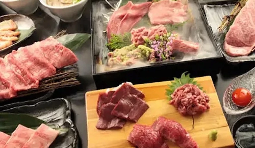木板與陶盤盛裝多款紅肉片與肉丸,白瓷碗湯品與蔬菜配菜整齊擺列,日式燒肉套餐豐盛精美。