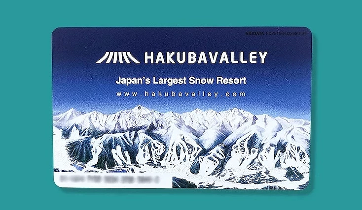 青綠色背景展示白色HAKUBAVALLEY標誌與黃色警告文字,深藍色滑雪票卡印有雪山風景與網址,日本最大滑雪度假村宣傳海報。