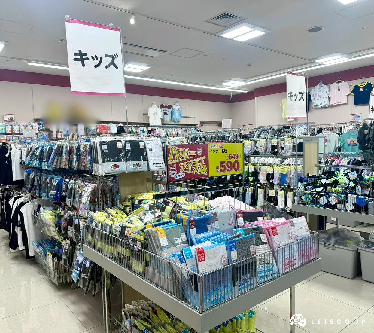 掛著寫有日文「キッズ(Kids)」招牌的童裝雜貨展示台,陳列了滿滿的兒童用品。
