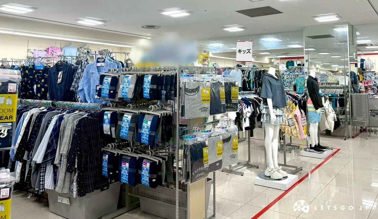男女裝服飾店內整齊排列的黑色吊掛衣架、長褲展示與白色人型模特兒。