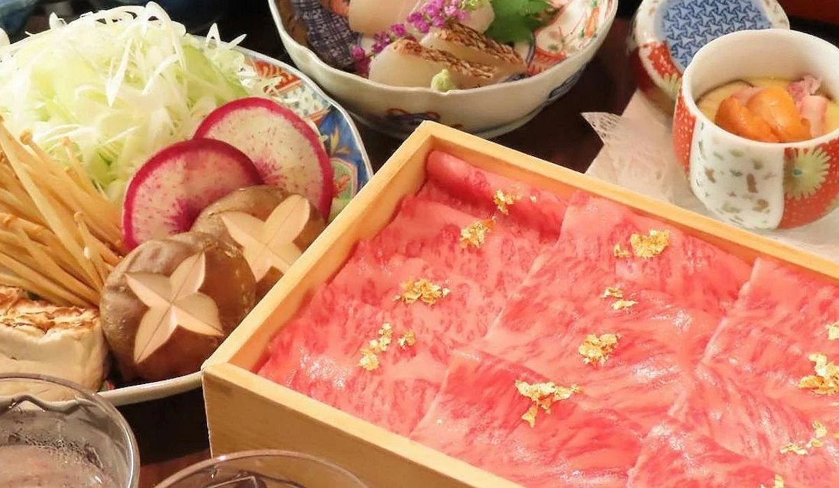 木盒中點綴金箔的和牛薄片與蔬菜