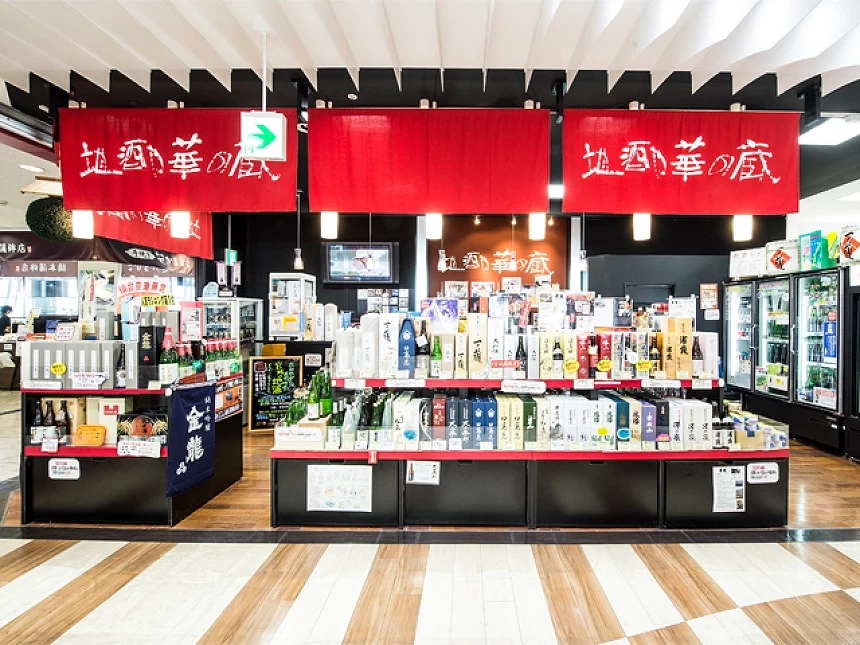 地酒店面掛著紅色暖簾,檯面陳列各式日本酒瓶