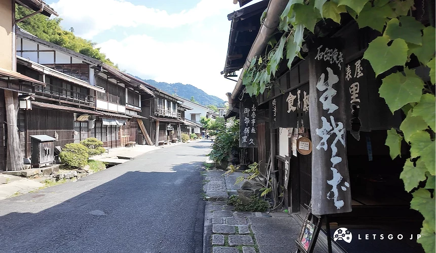 右側店舖門前立有「生粉打ち」大型木牌,旁附「御幣餅」字樣,街道兩側為連排木造建築
