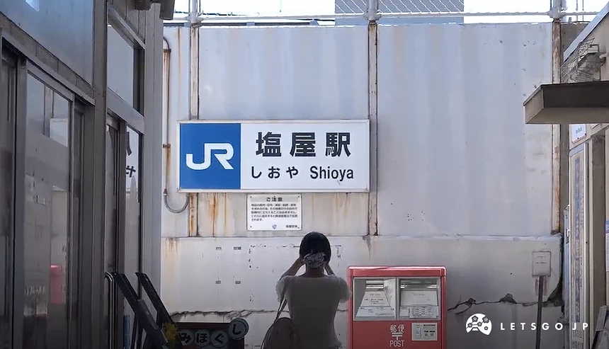 一位女性站在車站牌前拍照