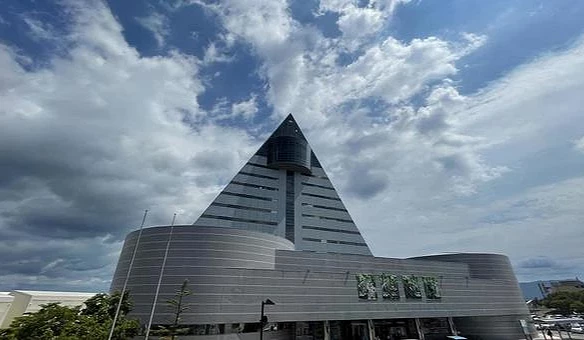 一棟三角建築,後面的天空是天藍色。