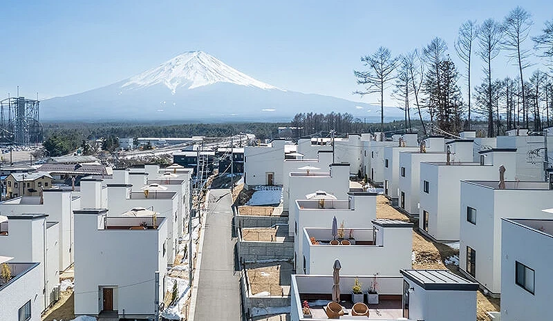 許多白色獨棟小屋坐落在飯店園區內,背後是富士山